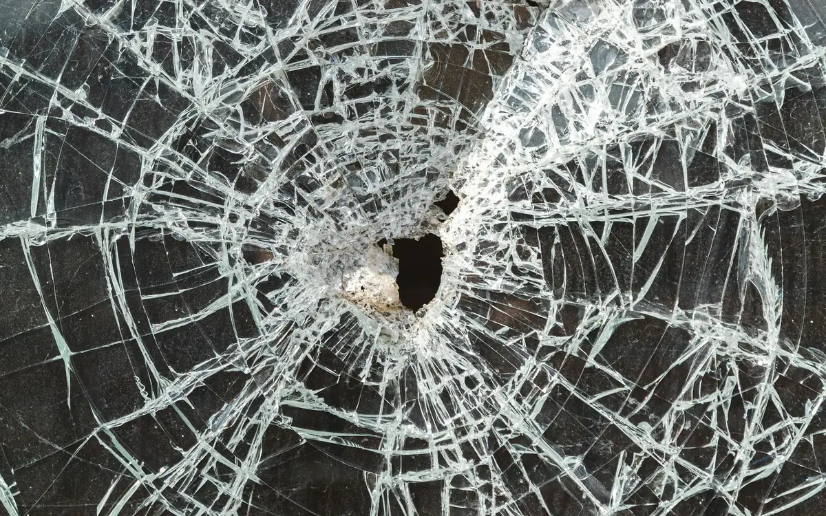 Glass cracked around an impact point but still in place